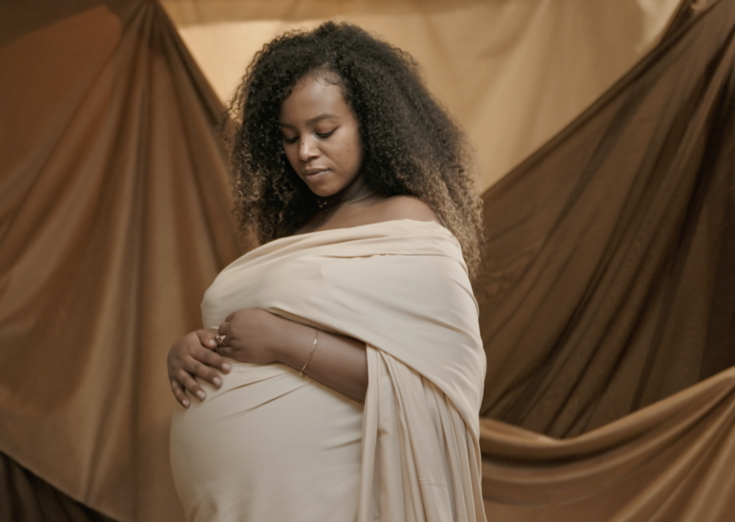 A screengrab of a Black, pregnant woman modeling in the Queen Collective documentary surrounding Black maternal health