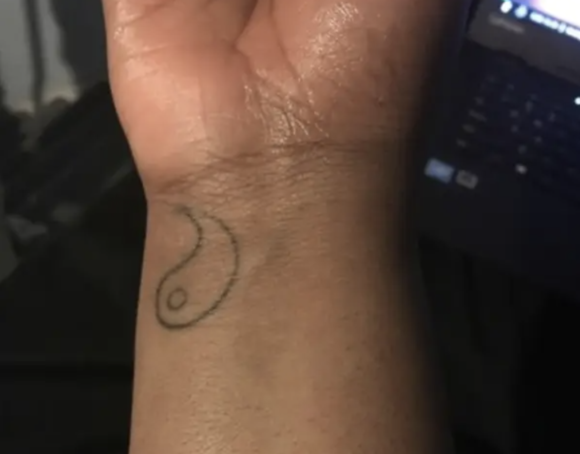 Half of a yin and yang symbol on someone&#x27;s wrist
