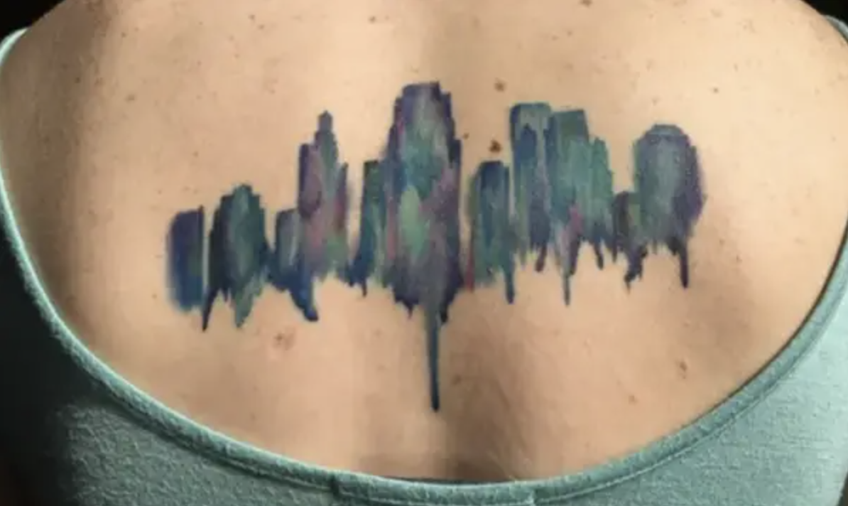 A back tattoo of a cityscape