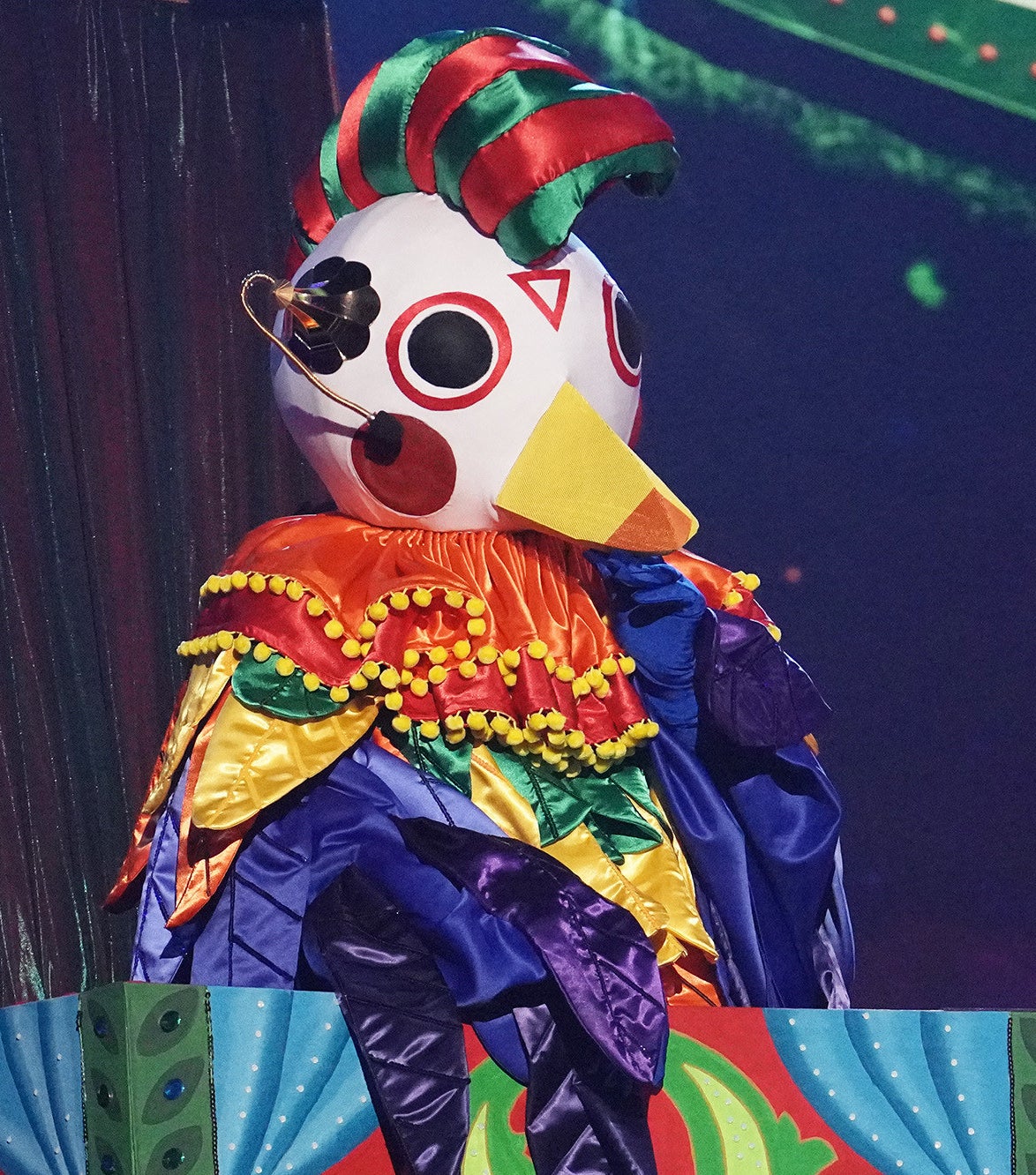 A costume with a bird head and colorful body