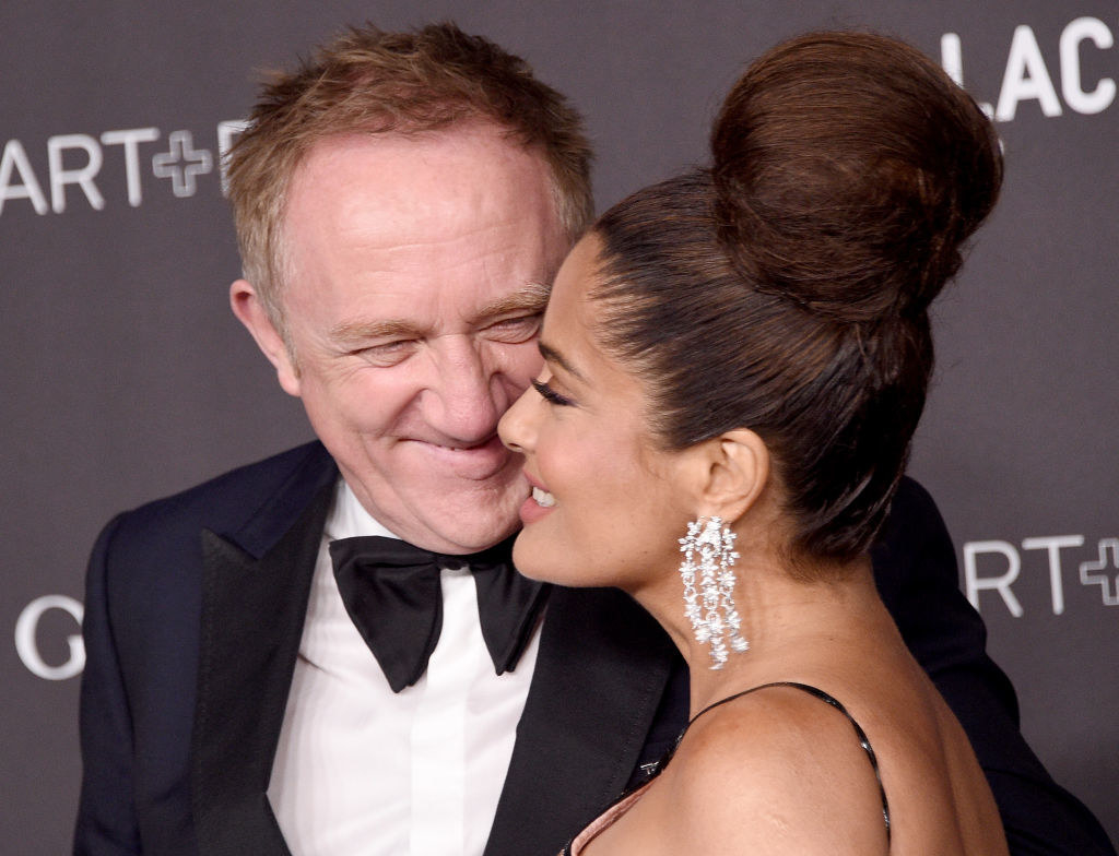 Salma Hayek and Francois-Henri Pinault smiling eat each other on a red carpet