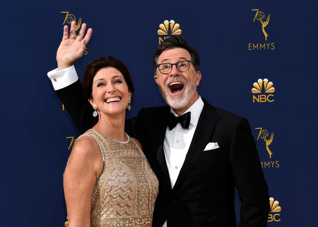 Stephen and Evelyn laughing and waving on a red carpet