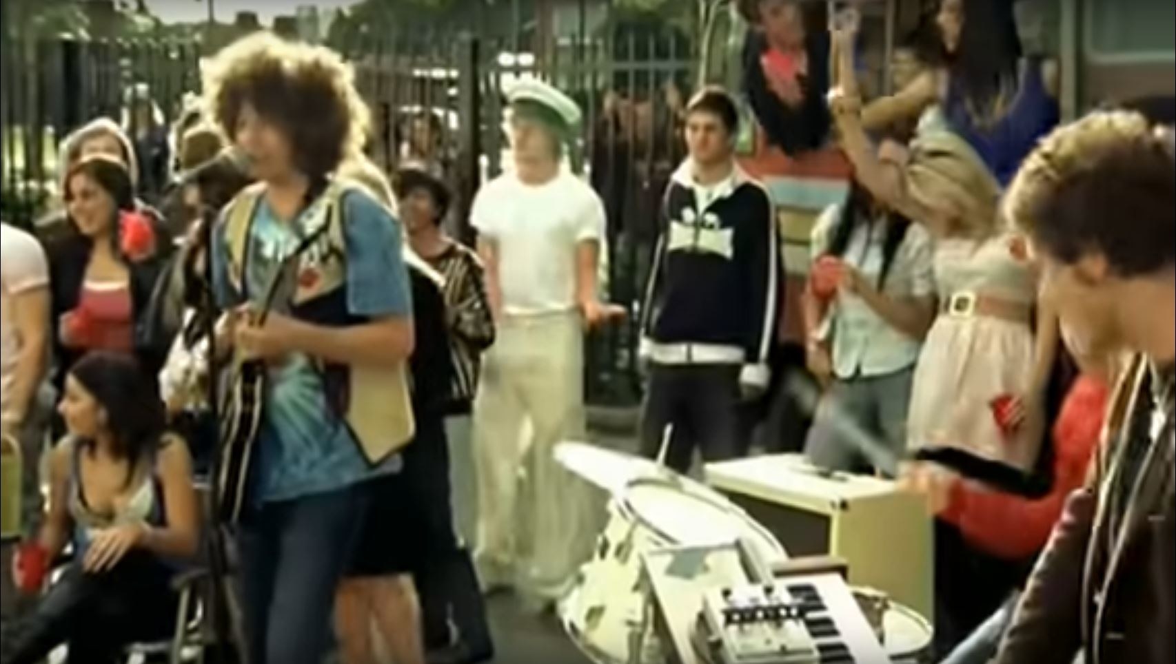 Vintage-looking footage of Wolfmother playing outside, surrounded by fans