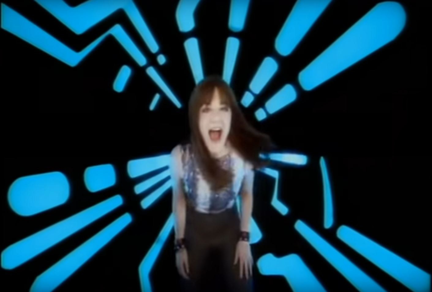 Vanessa Amorosi singing into a blue and black void, similar in style to the movie Tron