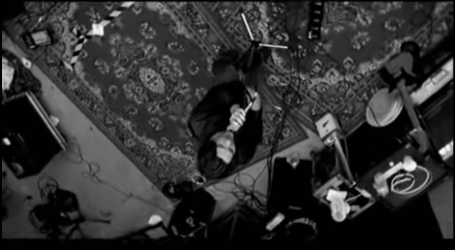 Powderfinger, in greyscale and upside down, playing in a carpeted room