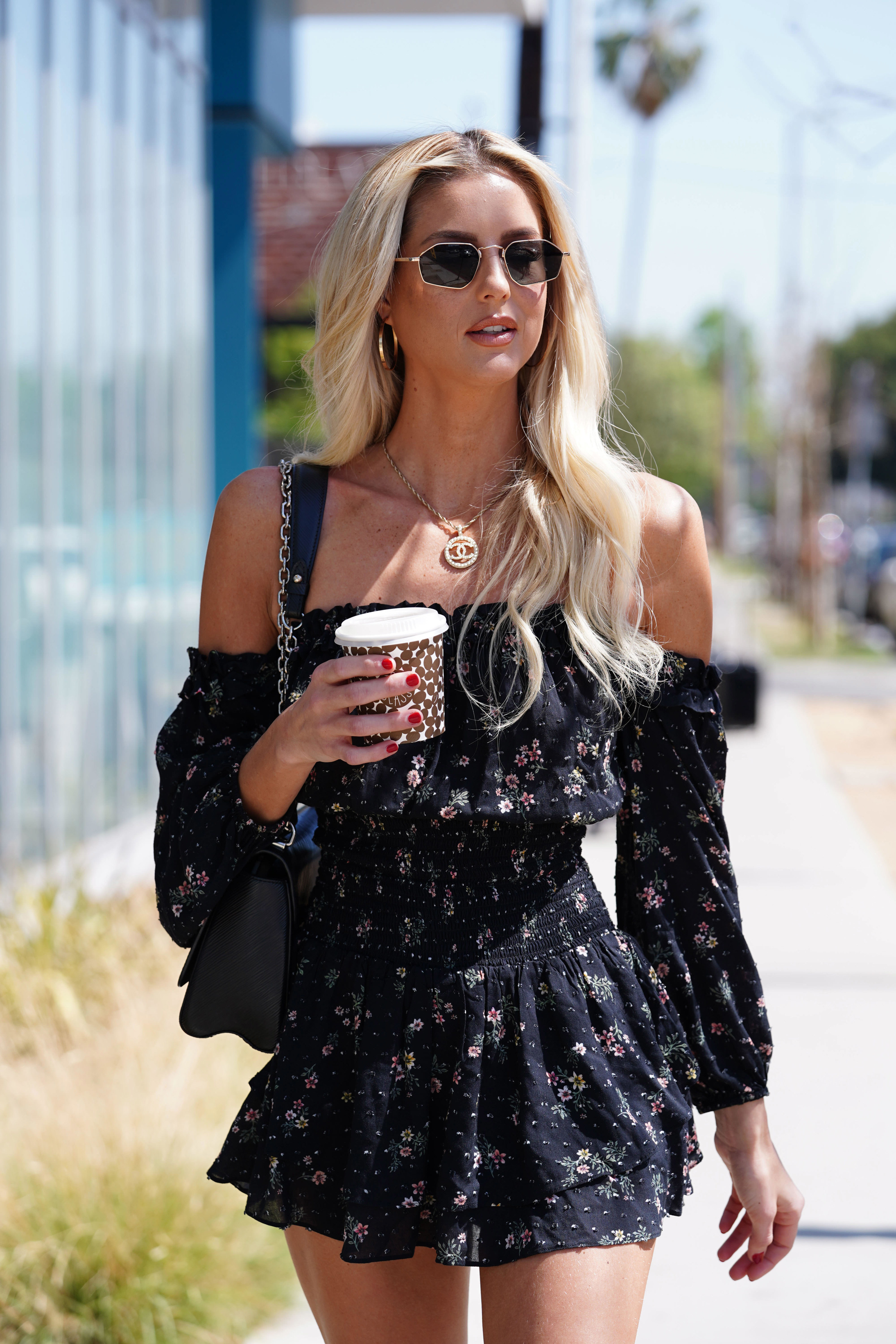 Emma walks down the street while holding coffee