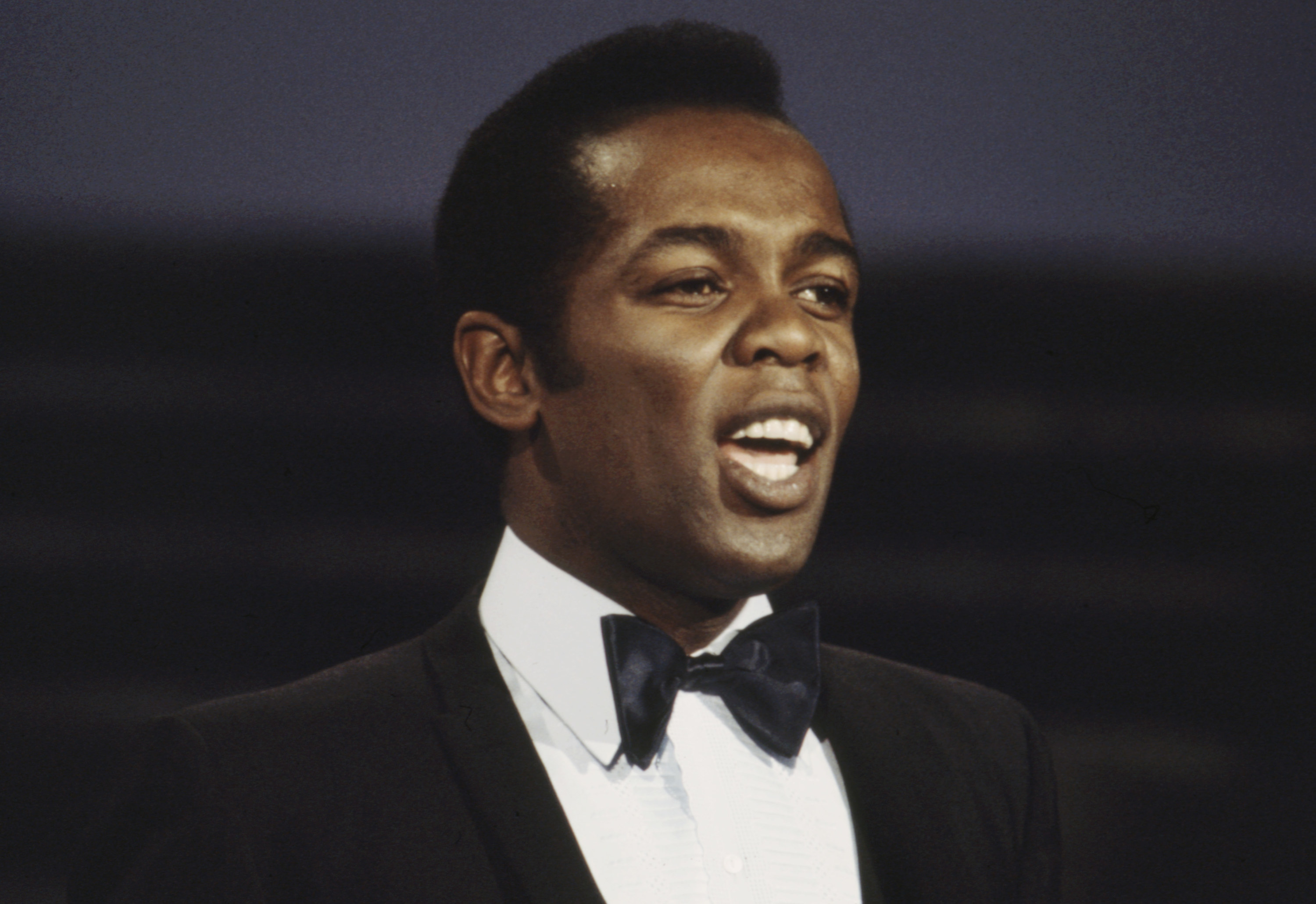 Lou Rawls performs on stage.