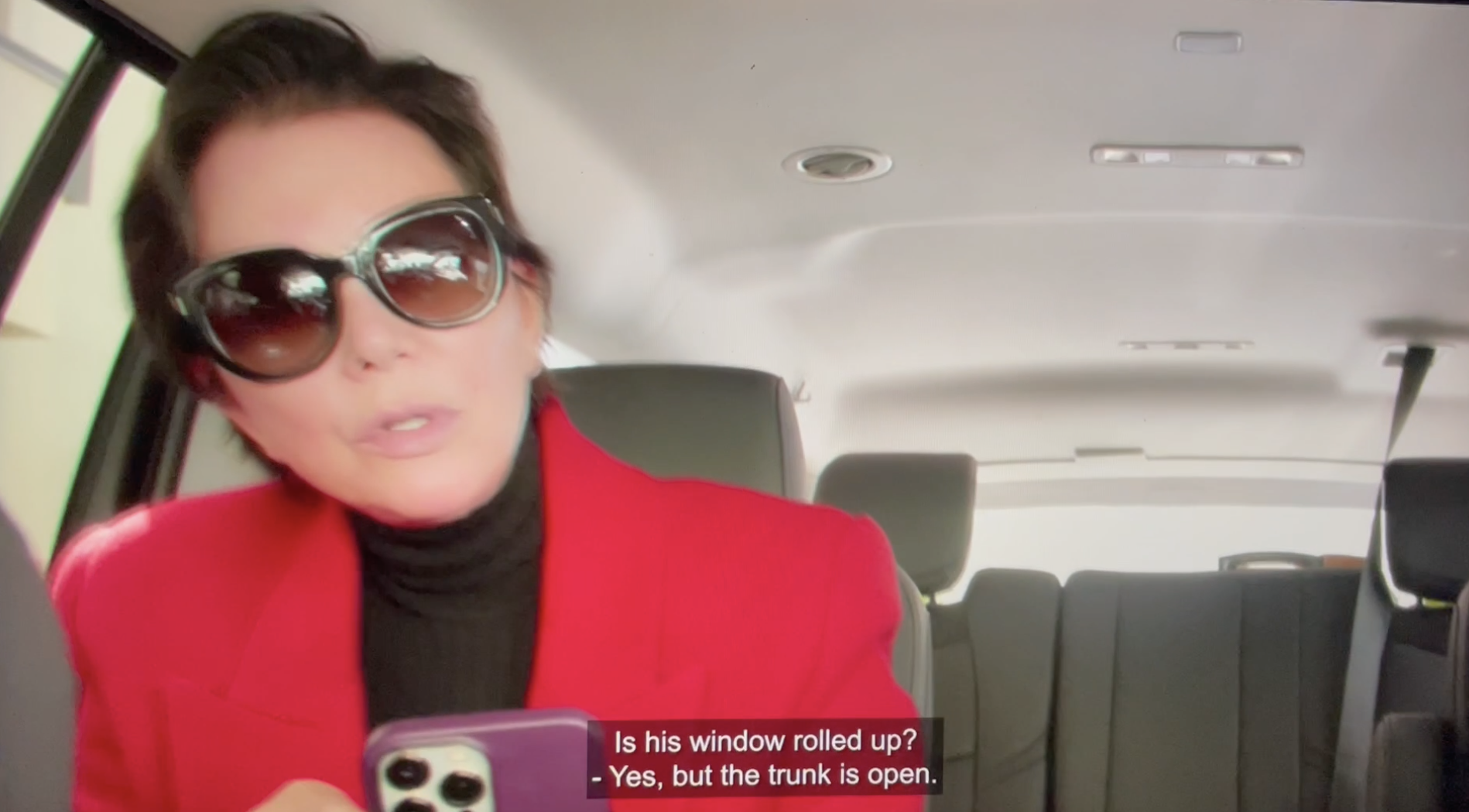 Kris Jenner in the backseat of a car.
