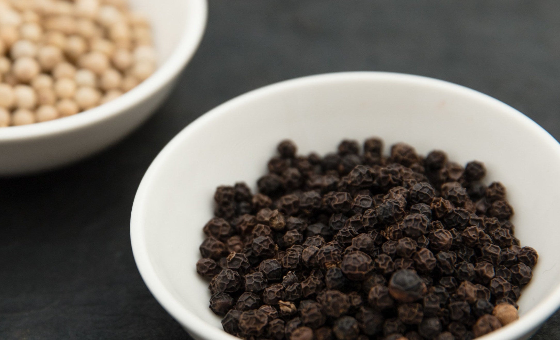 White plates with black and white peppercorns.