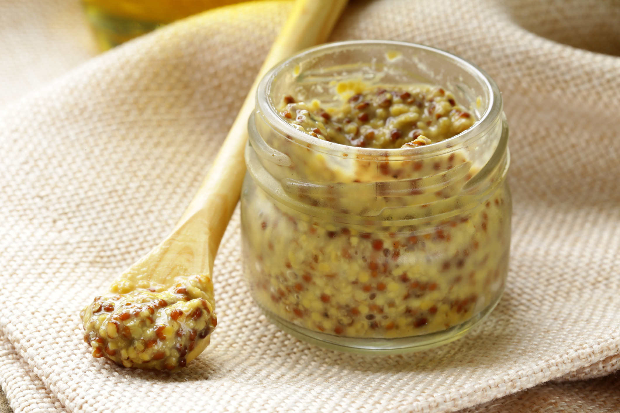 Traditional dijon mustard in a glass jar.
