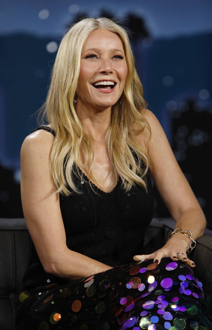 Gwyneth laughs while sitting