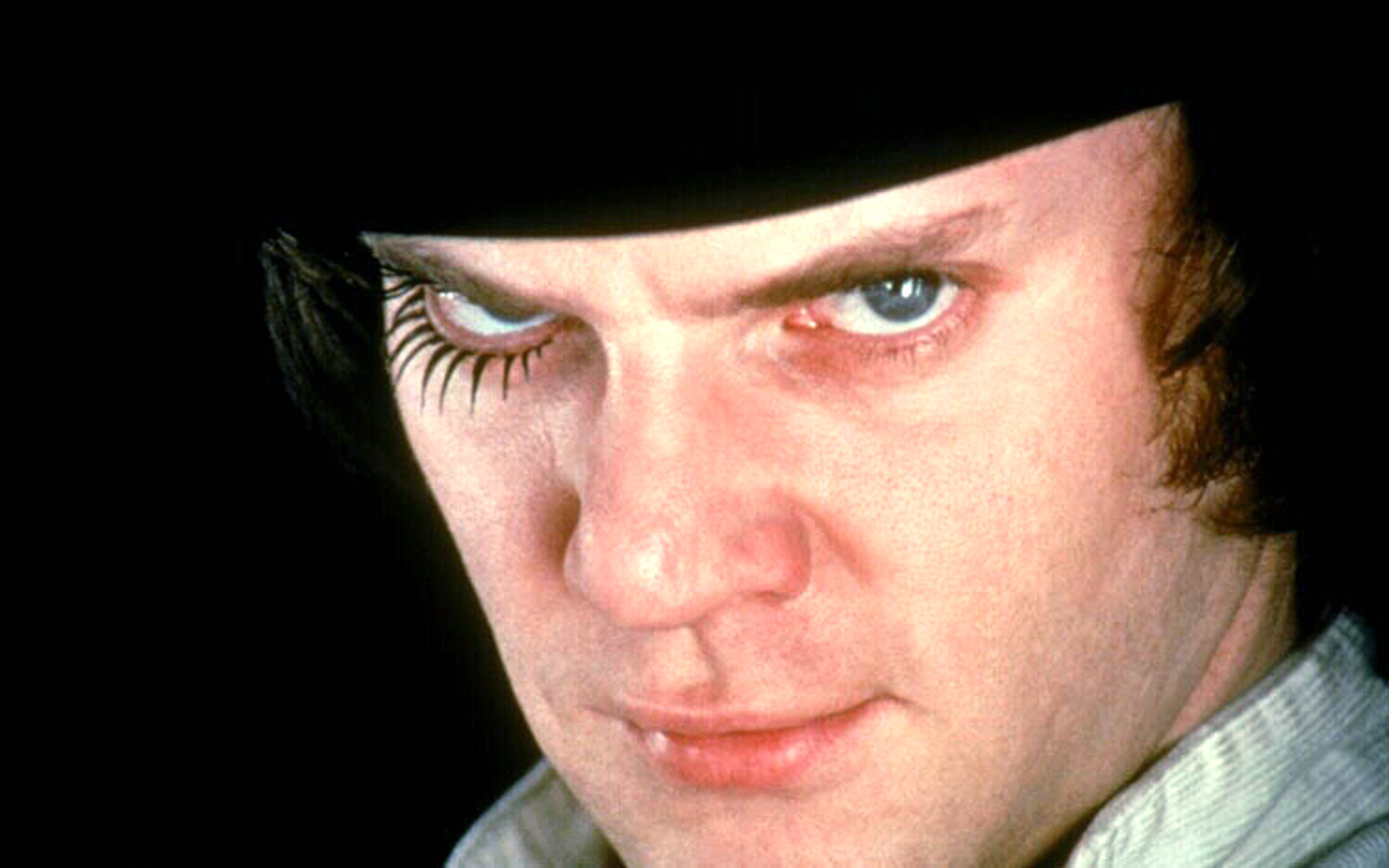 Malcolm McDowell looks menacingly into the camera