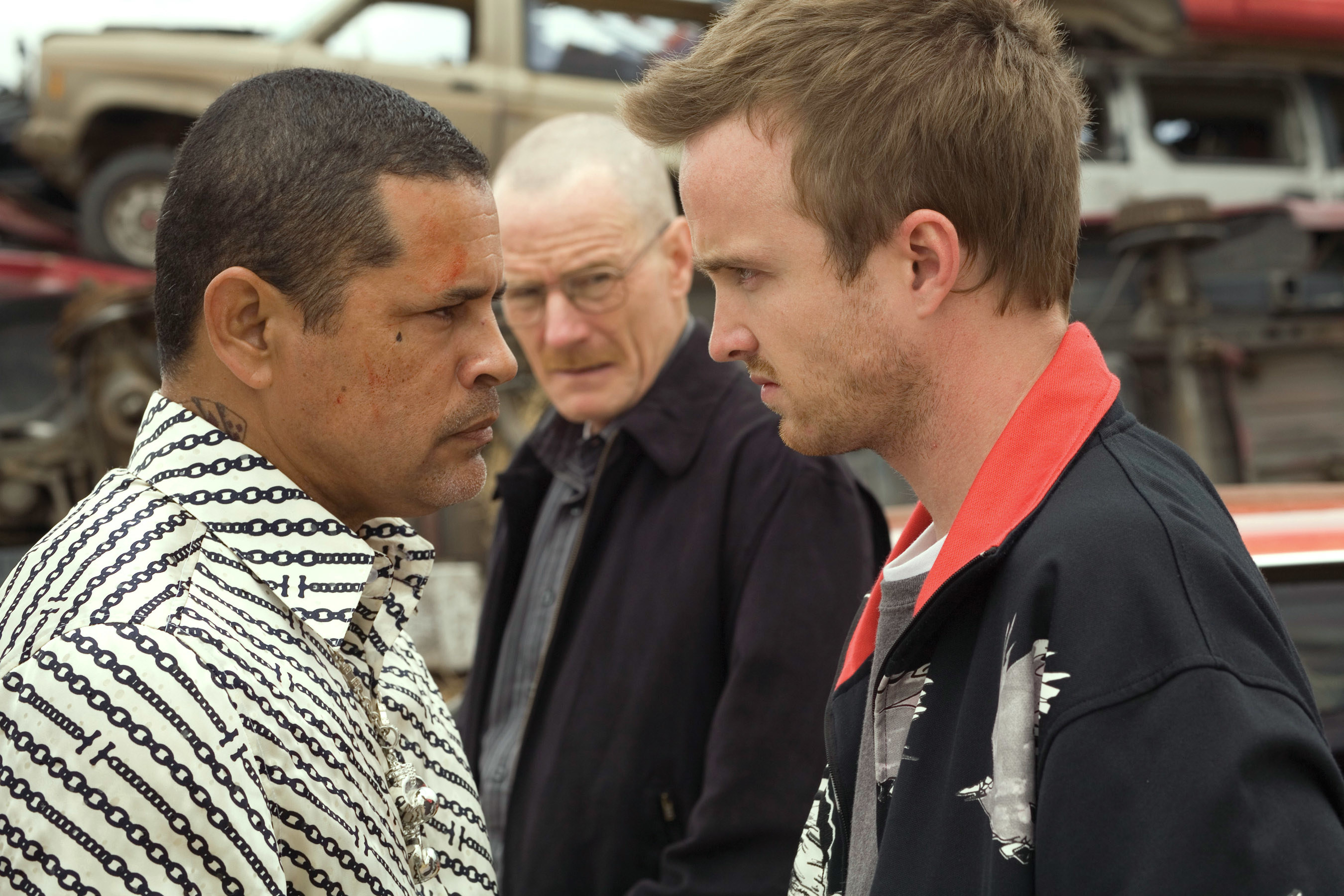 Raymond Cruz threatens Aaron Paul while Bryan Cranston looks at them