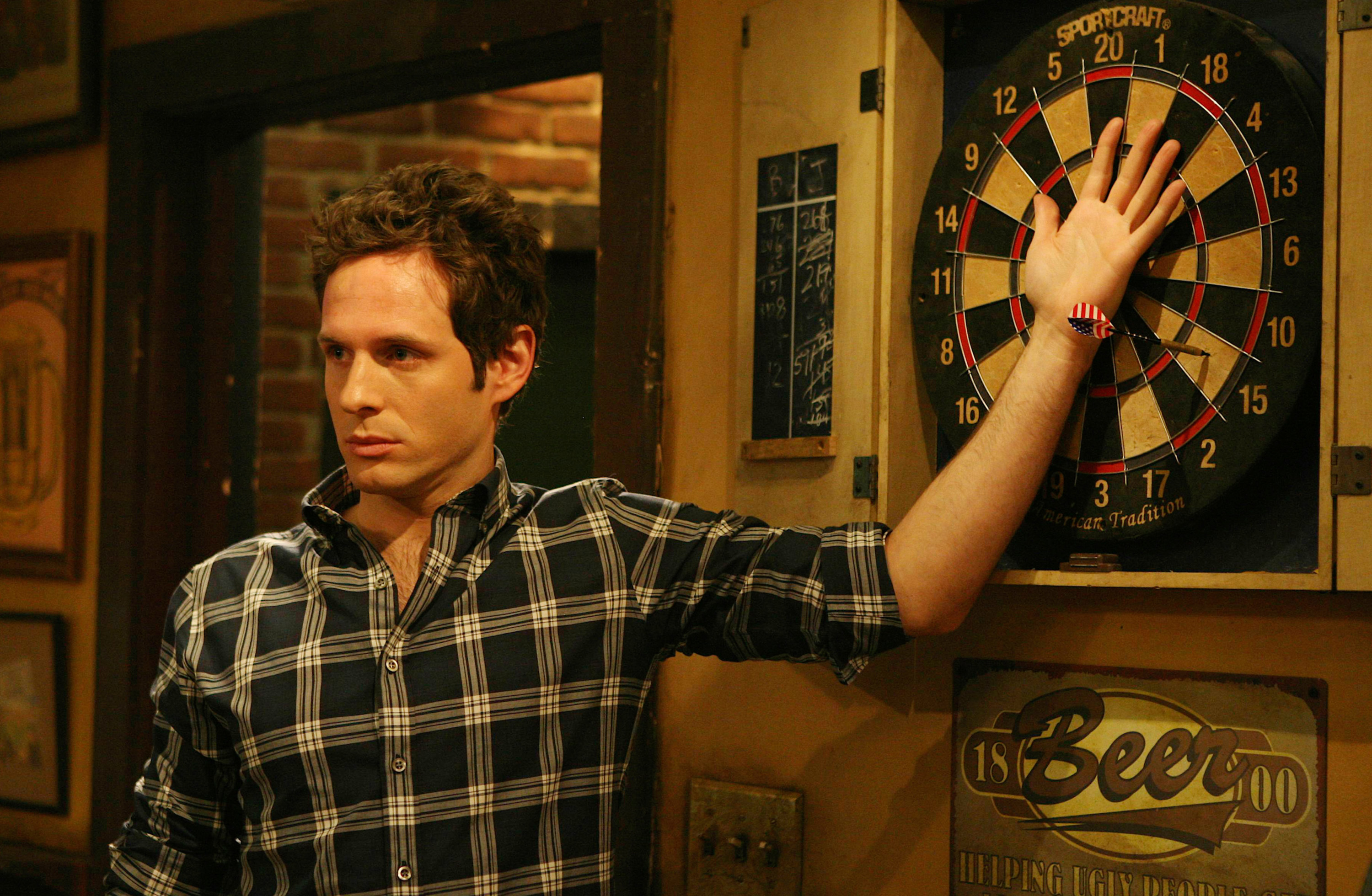 Glenn Howerton has his hand on a dart board