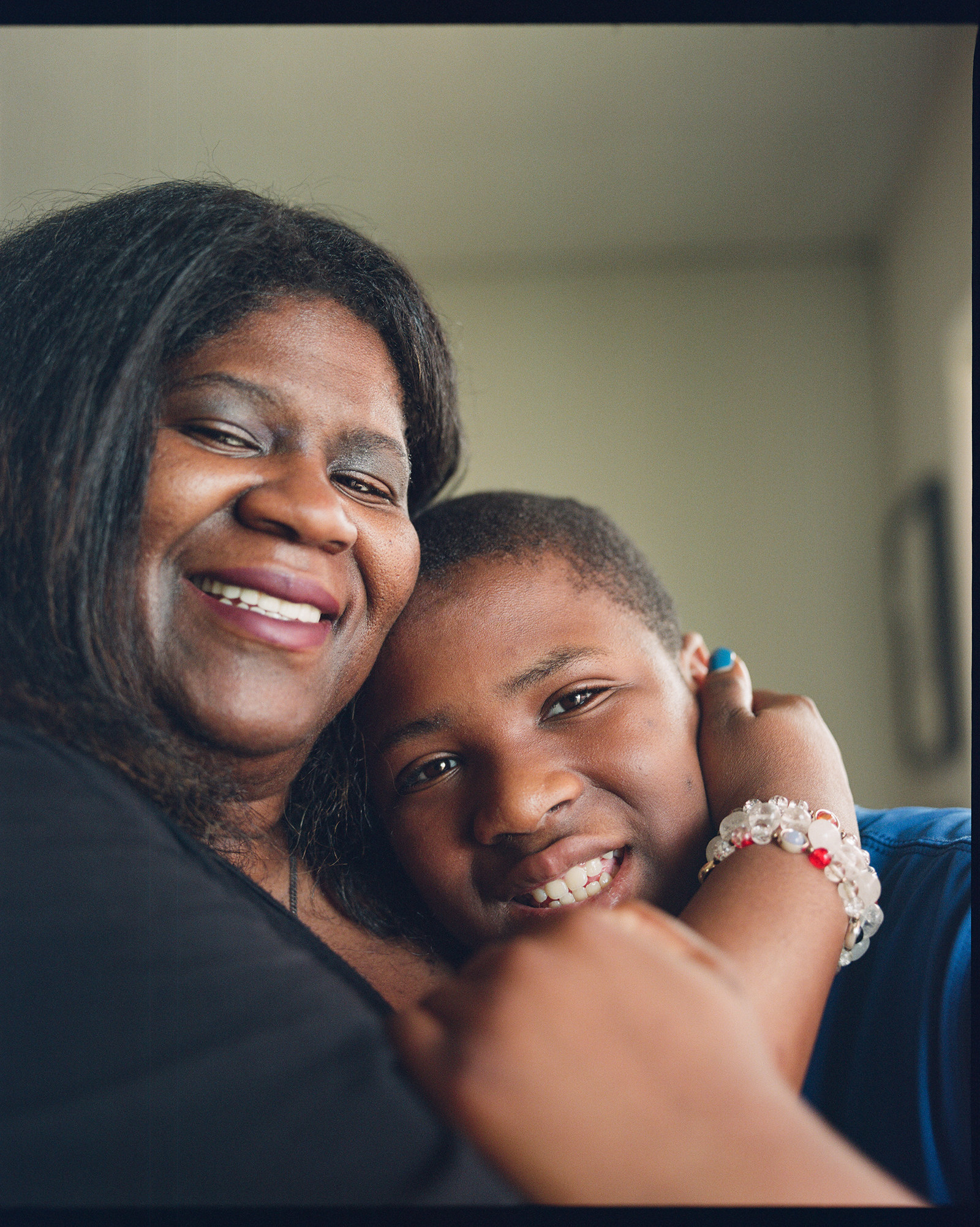 A woman hugs a young boy