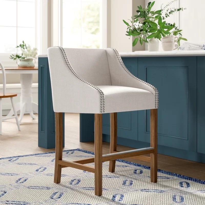 A white bar stool with brown legs at a blue table