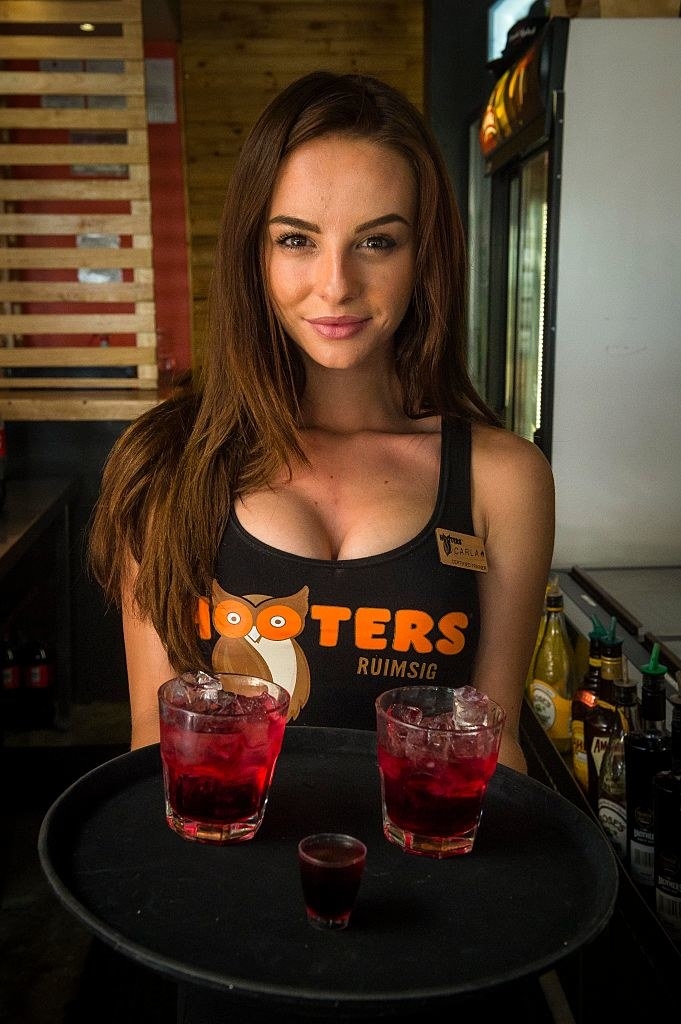 A Hooters girl holding a tray of drinks.