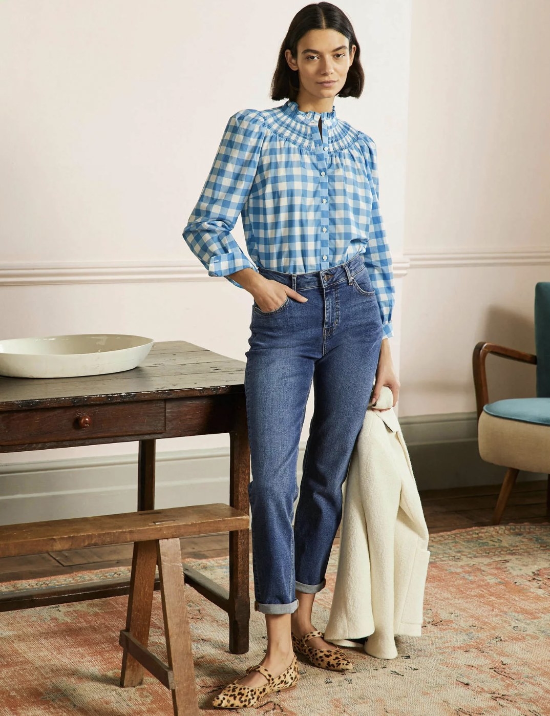 Model wearing the blue gingham blouse tucked into jeans