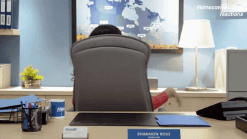 A woman swiveling around in an office chair at a desk
