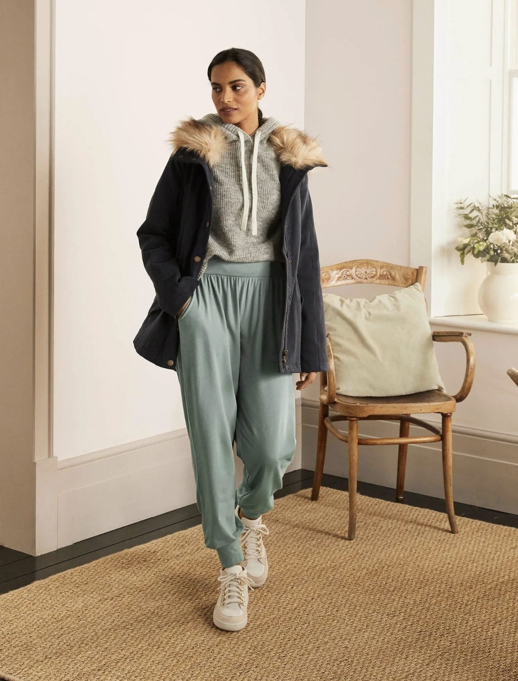 model wearing the light green joggers with sneakers, sweatshirt and winter coat