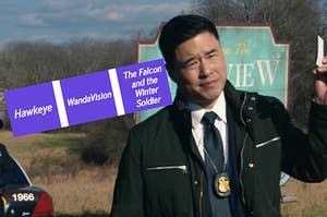 Jimmy Woo holds out his business card while standing in front of a sign for Westview, NJ