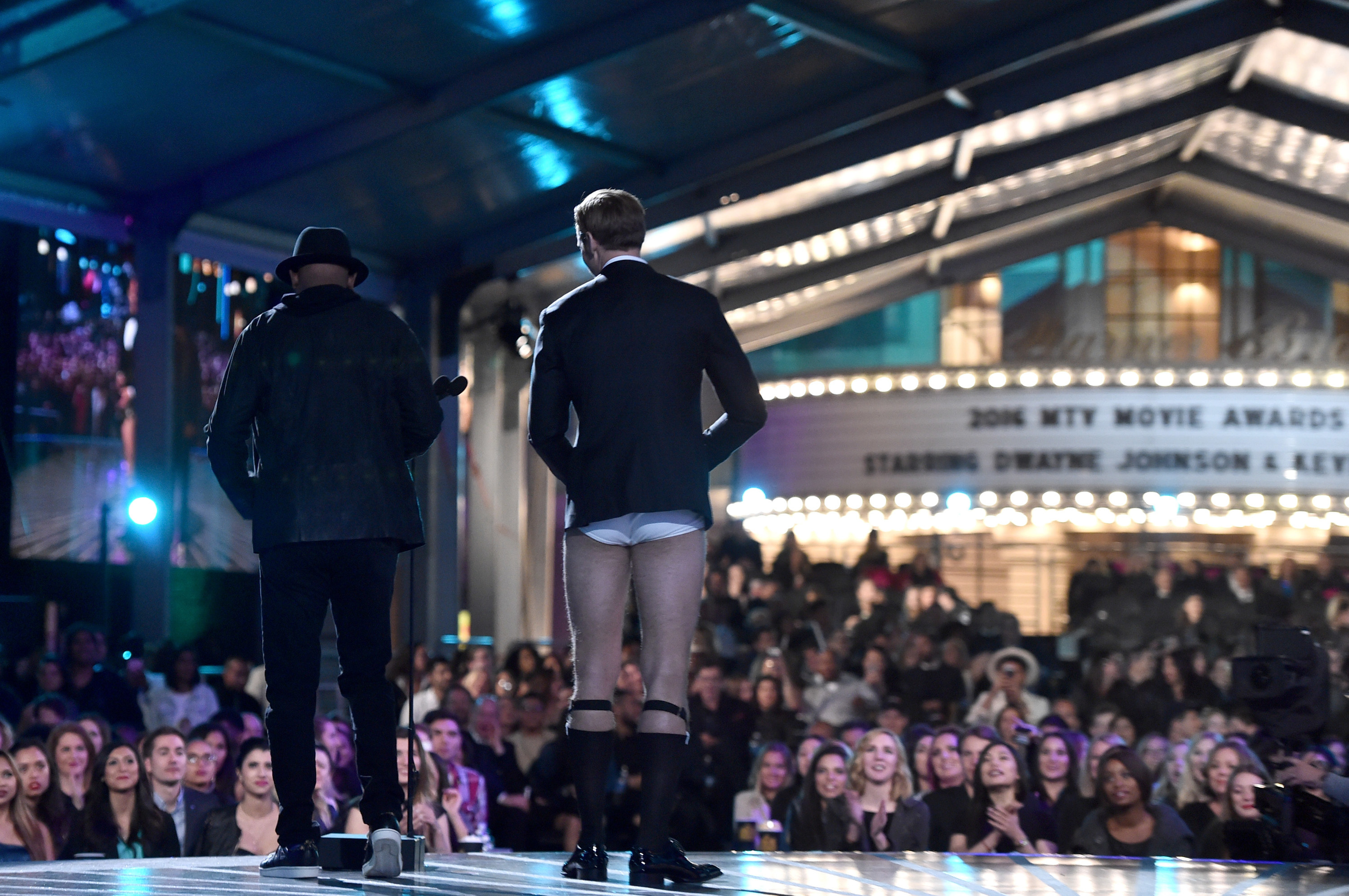 Alexander stands onstage next to Samuel
