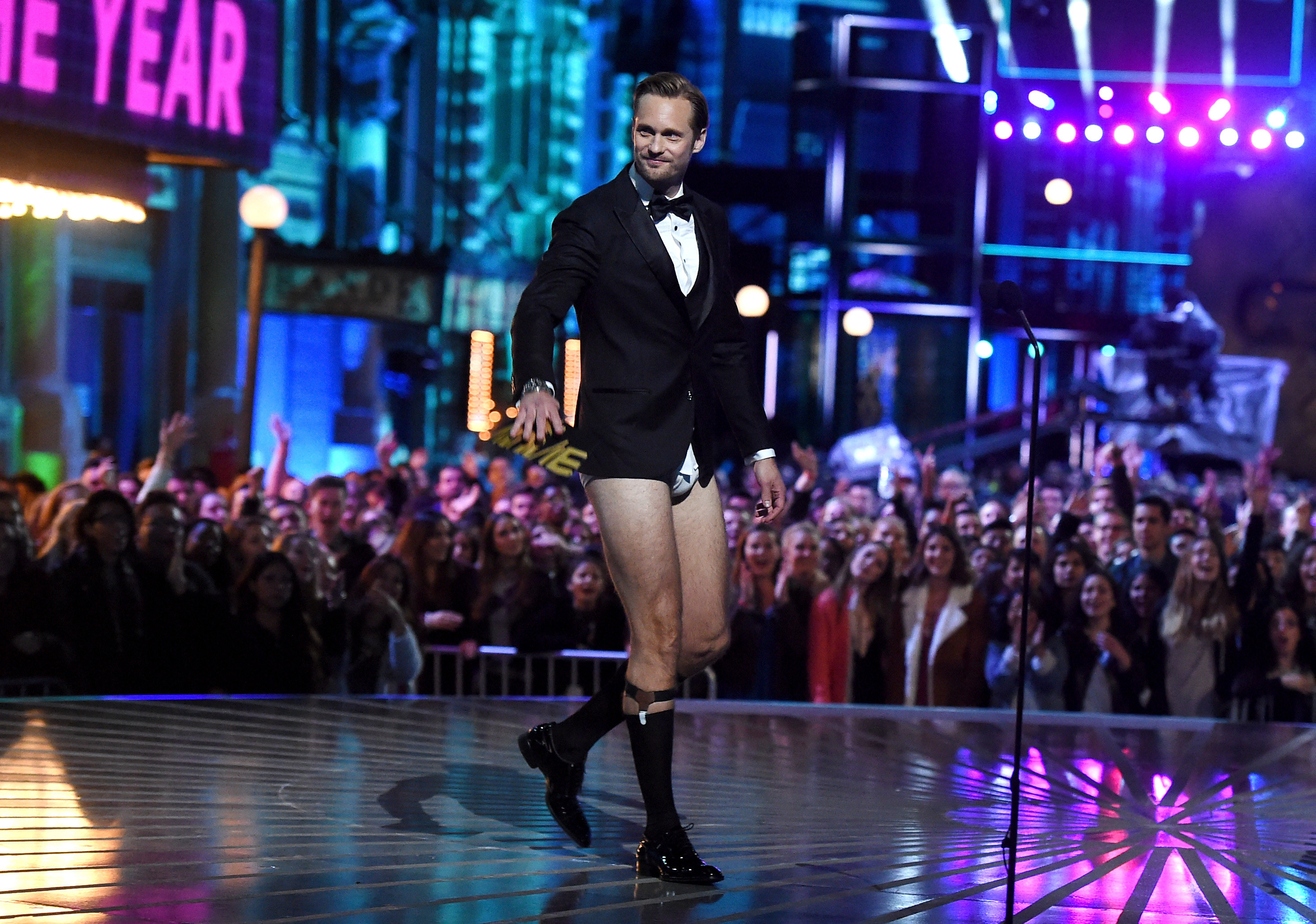 Alexander walks on stage with no pants on