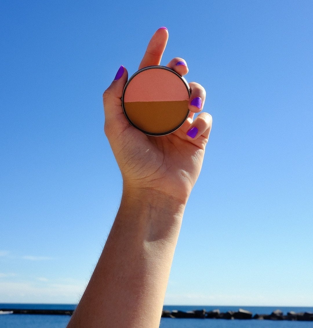 a person holding up the two-part blush and bronzer tin