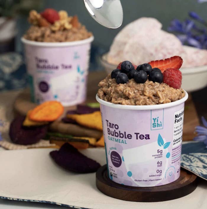 Taro Bubble Tea Oatmeal in a cup with blueberries and strawberries on top