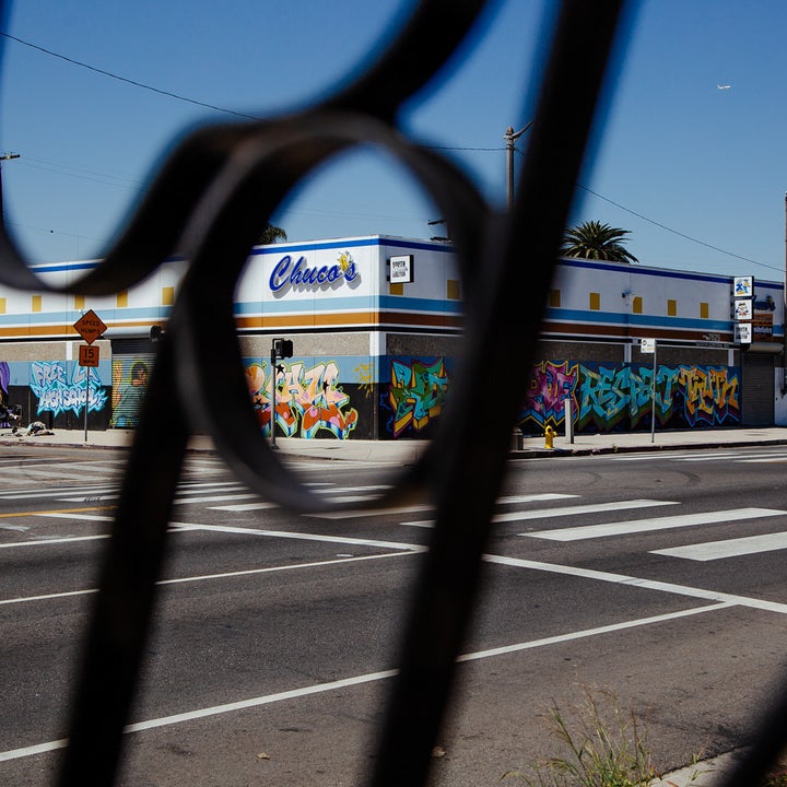 A building with the name Chuco's on the side, seen through a wrought-iron fence