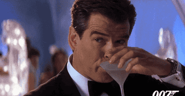 Pierce Brosnan as James Bond takes a sip of his martini.