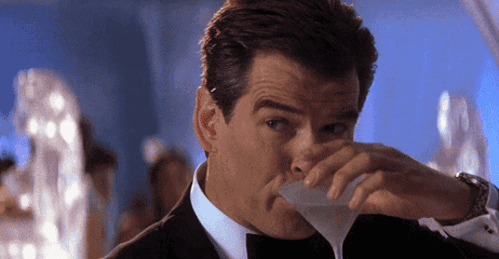 Pierce Brosnan as James Bond takes a sip of his martini.