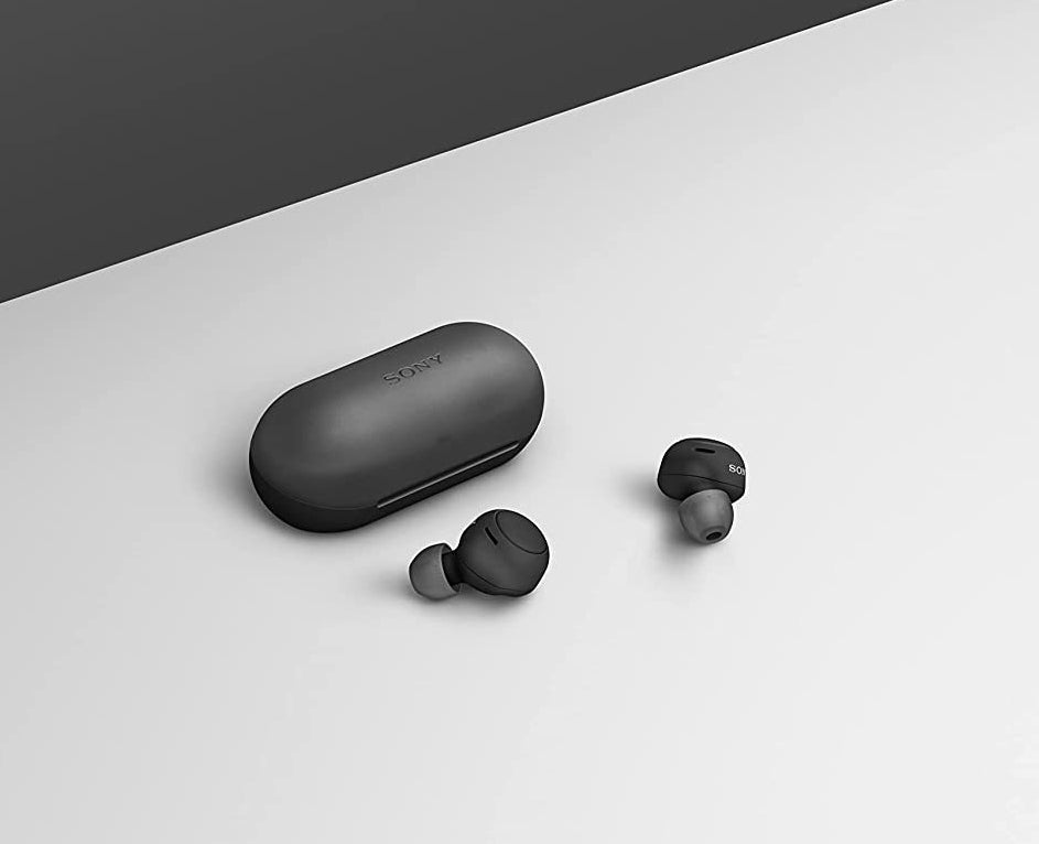 the earbuds on a flat surface next to their case