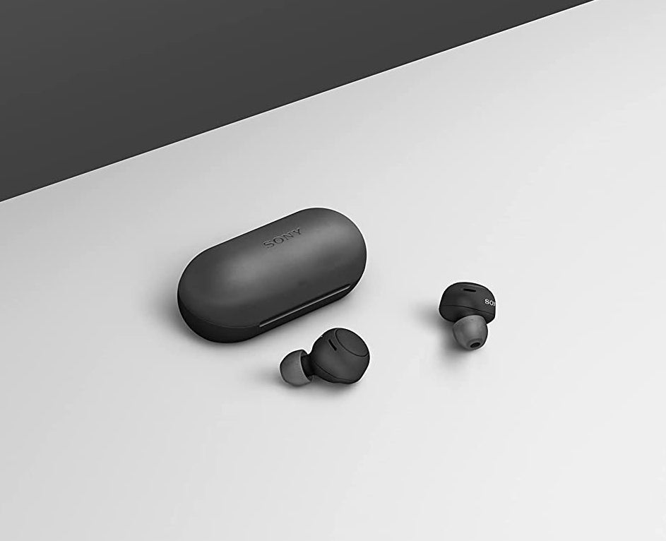 the earbuds on a flat surface next to their case