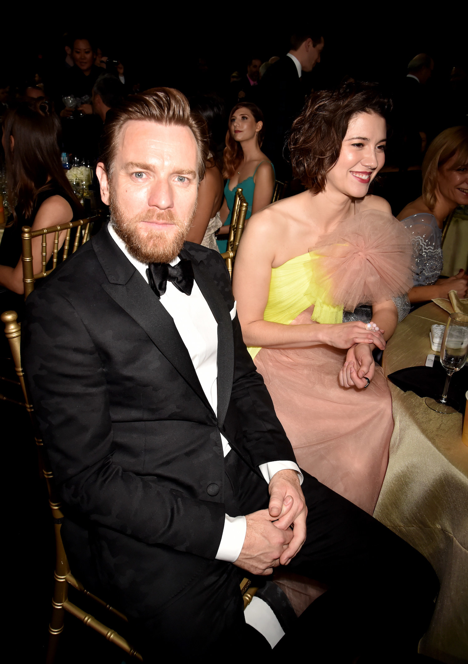 Ewan sits next to Mary at an event