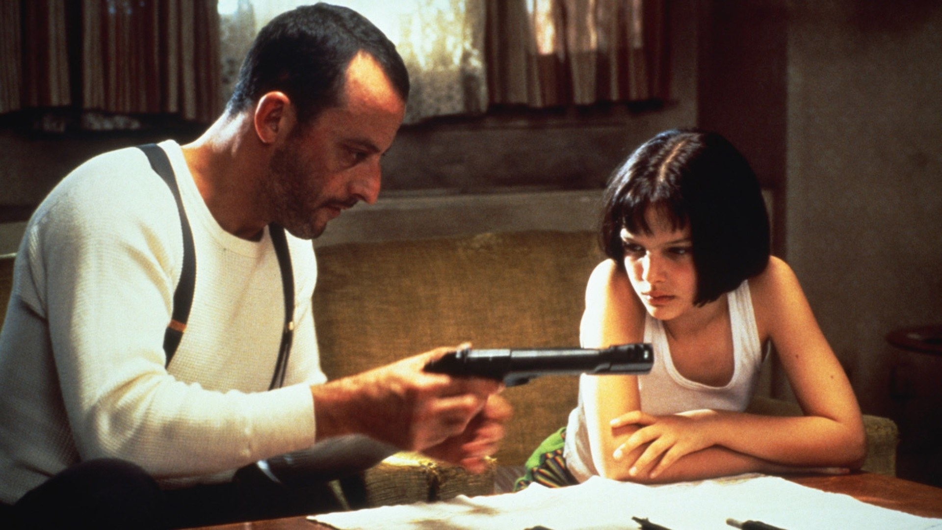 Jean Reno shows a gun to Natalie