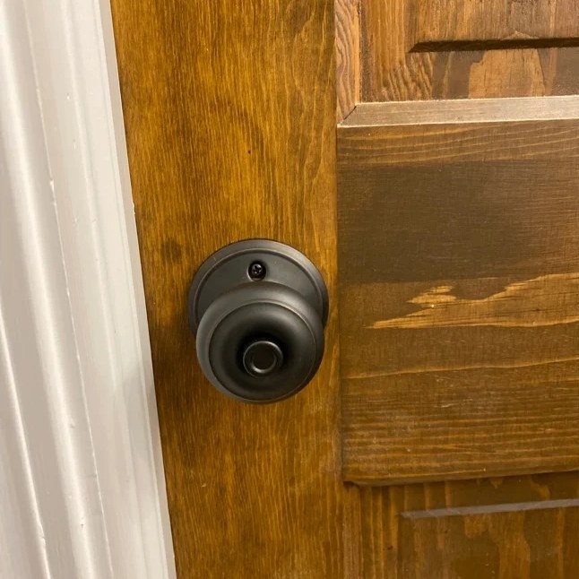 A reviewer&#x27;s image of a bed and bath lock that is mounted onto a door