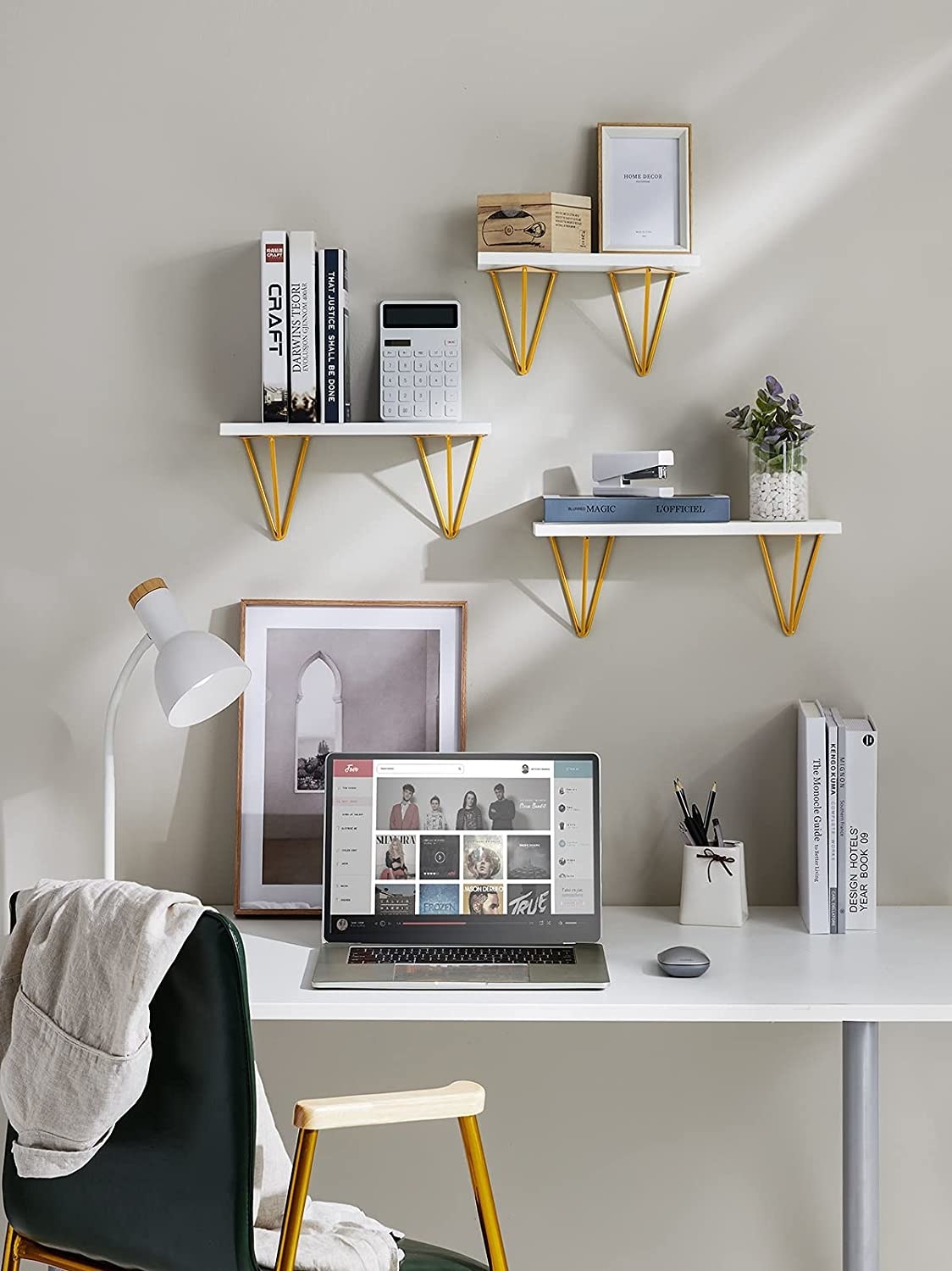 Three shelves with decor and knickknacks on them above a desk