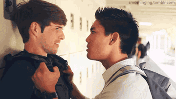 GIF of a student pushing another against a locker, and the student being pushed mistakenly goes in for a kiss
