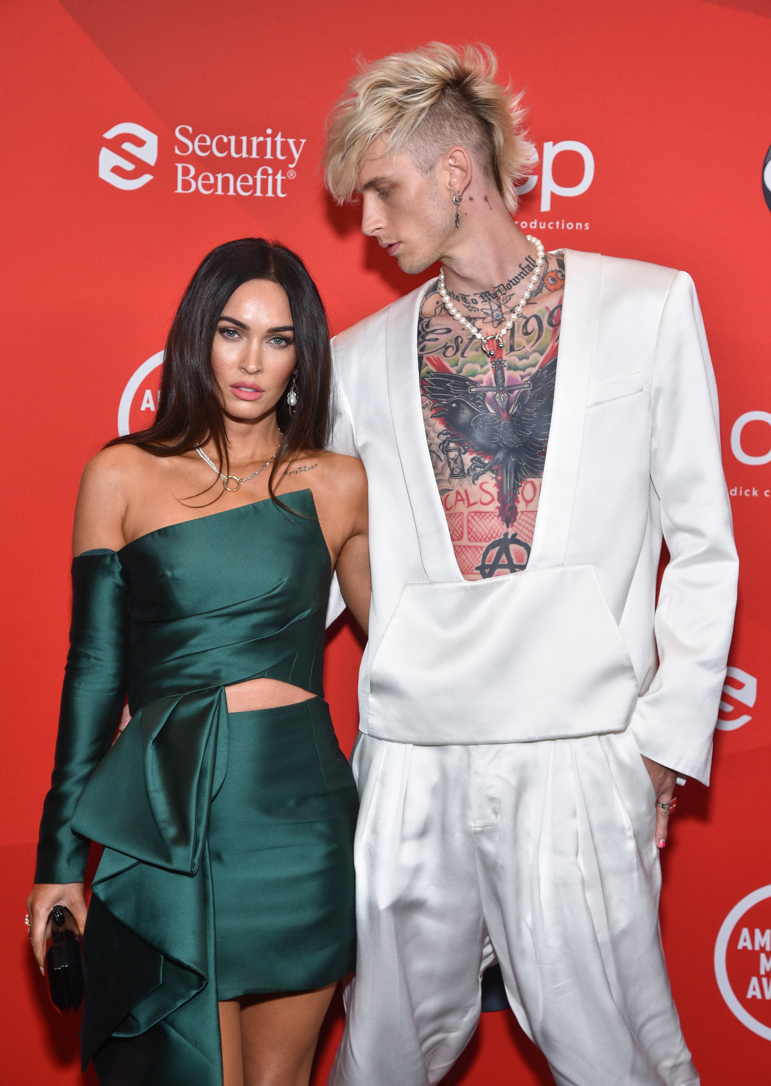 MGK looks down on Megan while posing on a red carpet