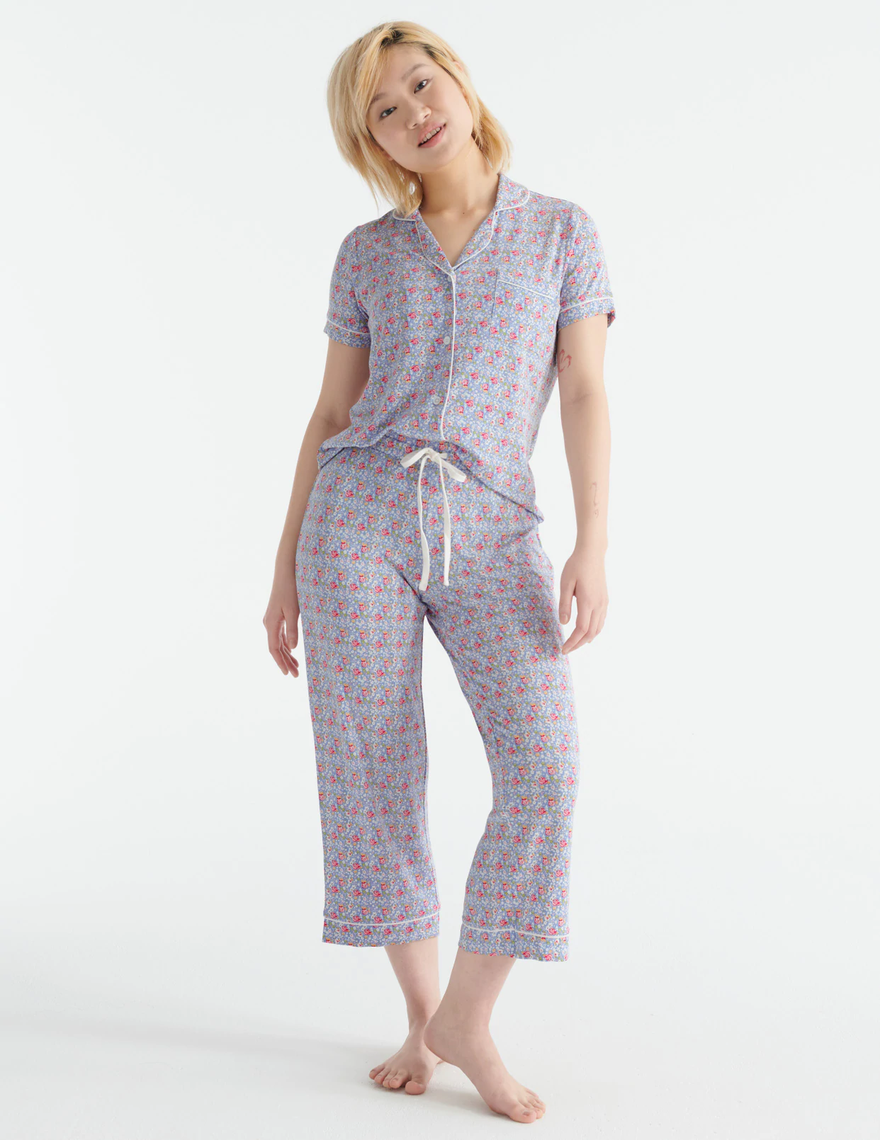 A person wearing a pyjama top and matching pants