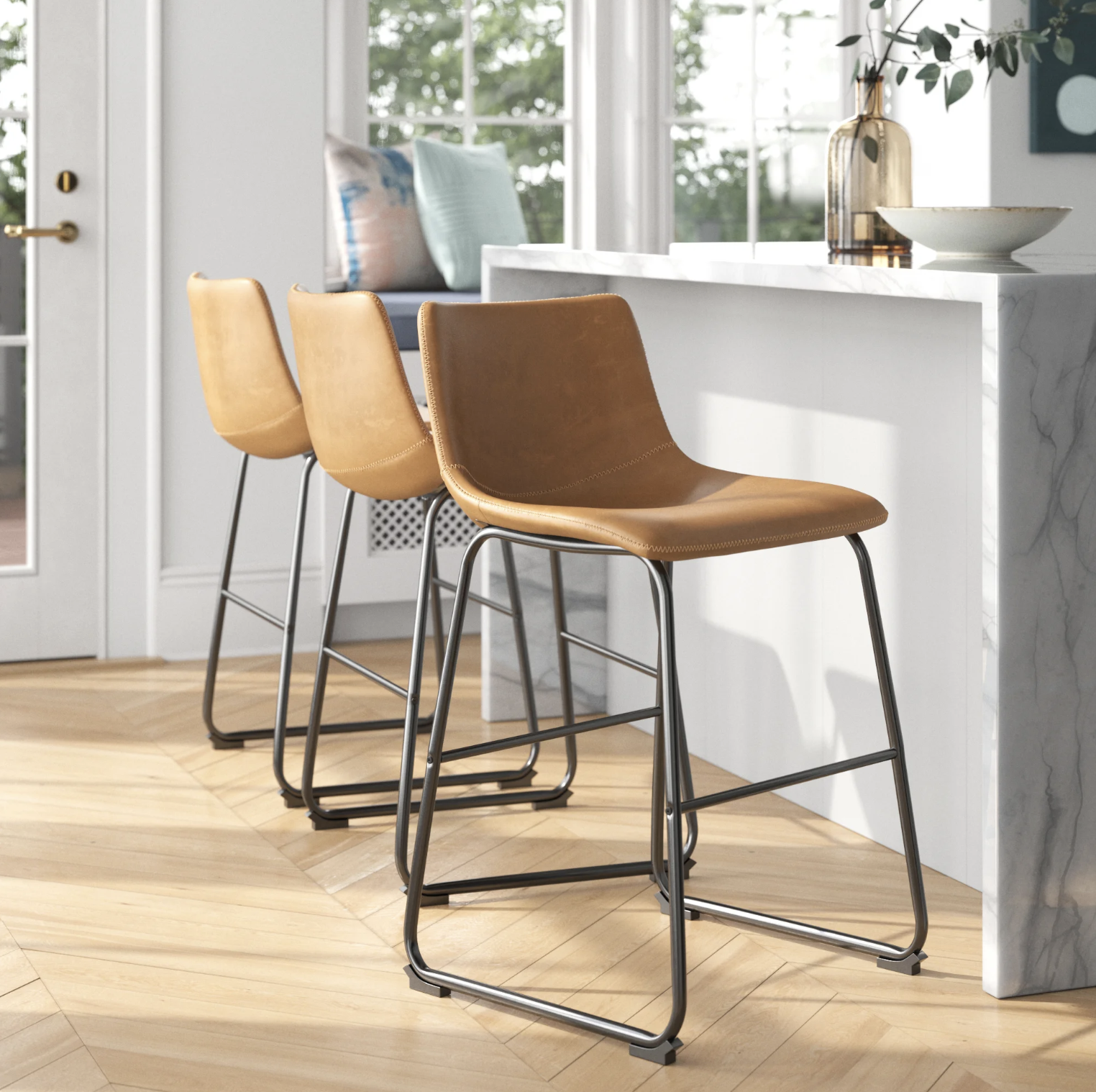 The three bar stool in a bright kitchen pulled up to a marble counter