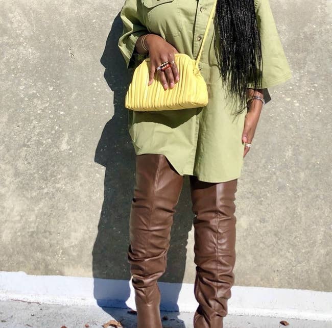 An adult wears the bright yellow textured bag while standing outside and posing