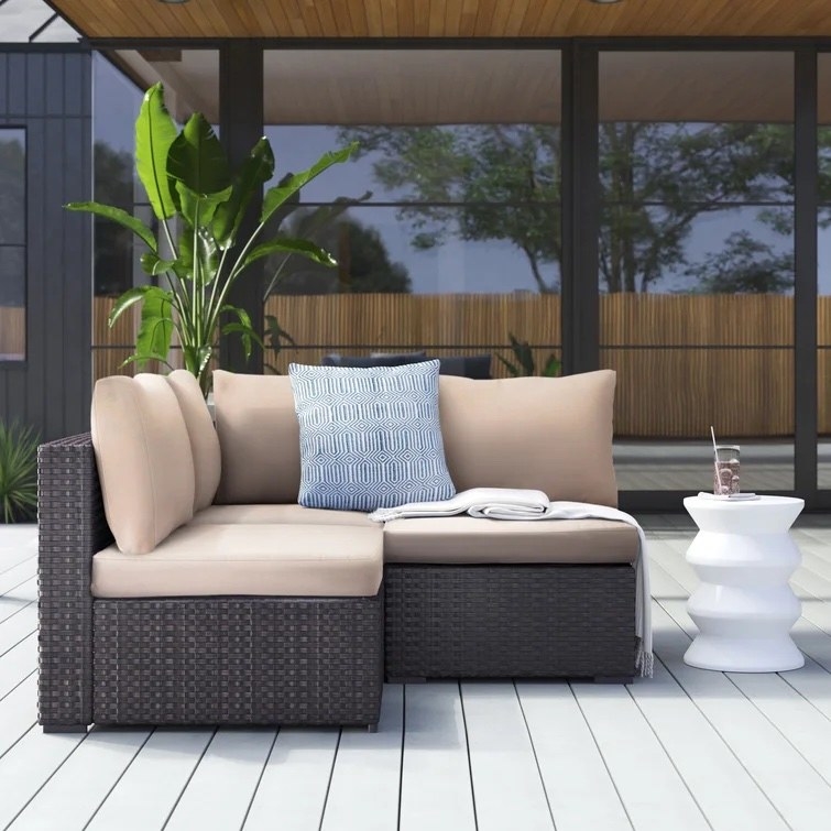 The outdoor sectional on a deck in a backyard
