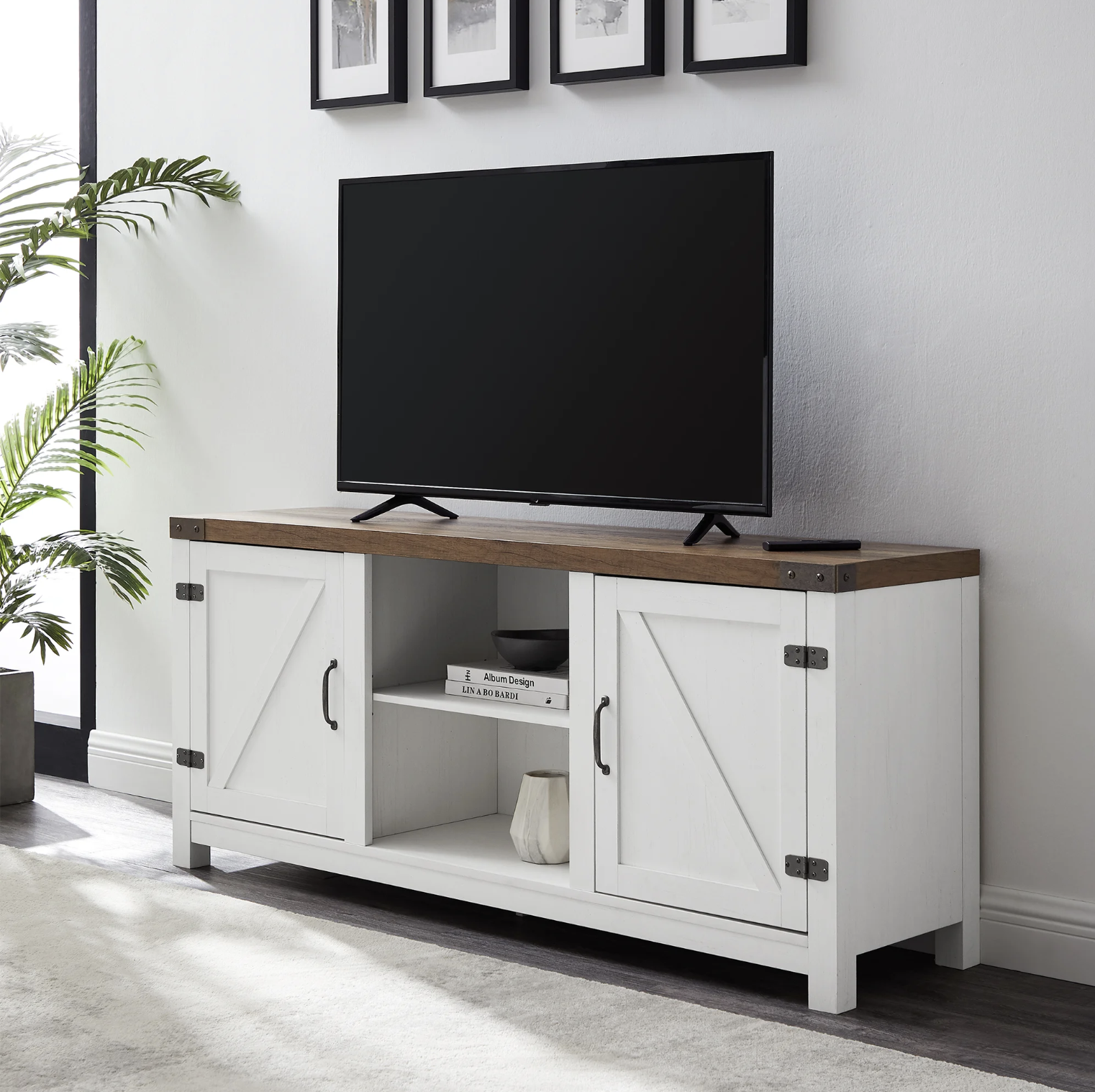 The TV stand with a flat screen TV on top and books on the shelves