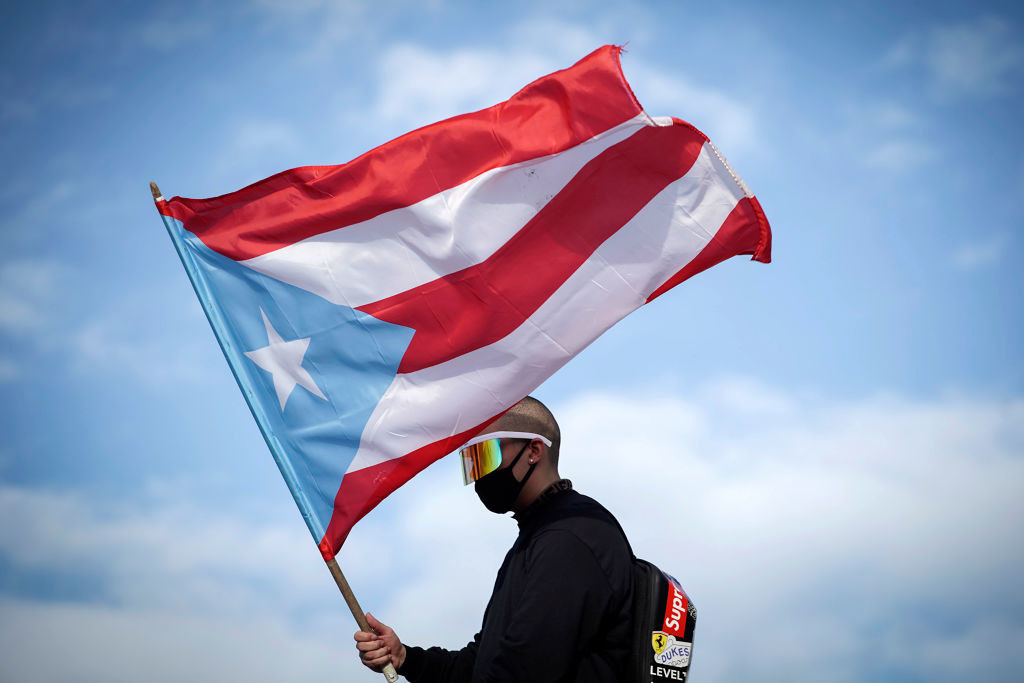 A person holding a large Puerto Rican flag