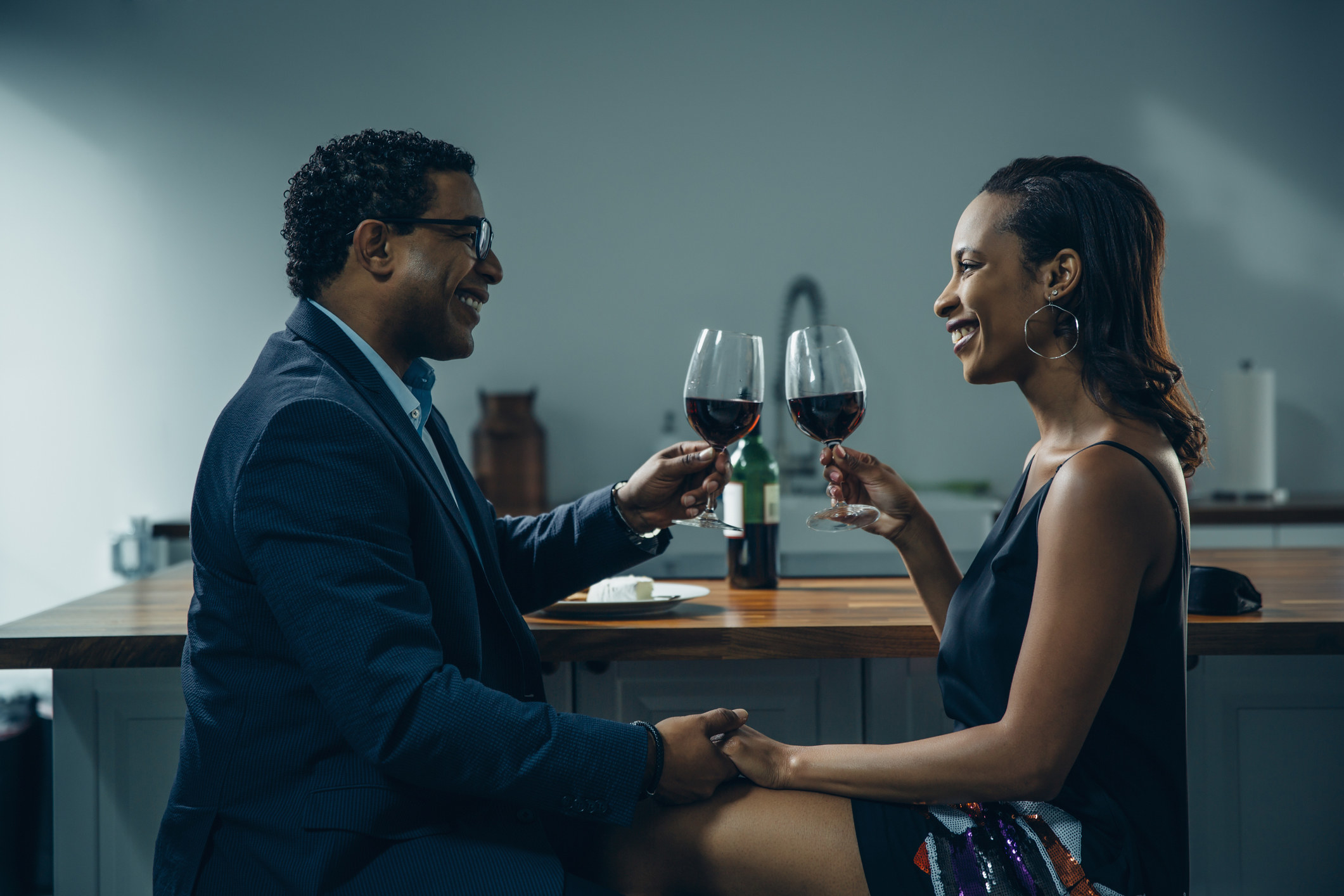 Couple toasting with wine at a counter