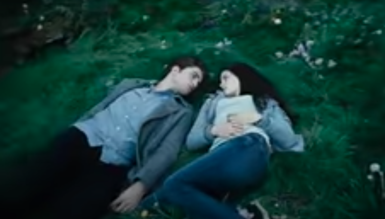 Bella and Edward lying in the grass staring at each other