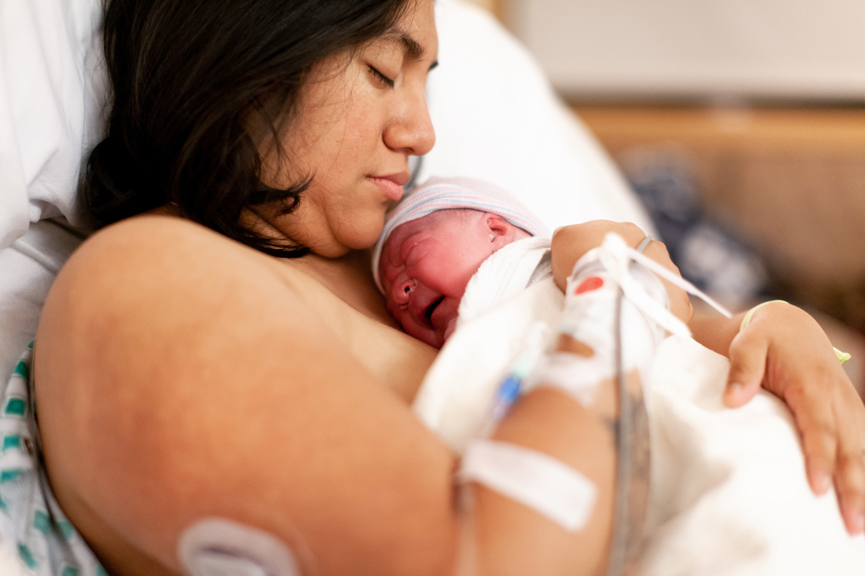 Родила 2022. Холдинг новорожденного. A woman after giving Birth in a Hospital holds a Newborn.