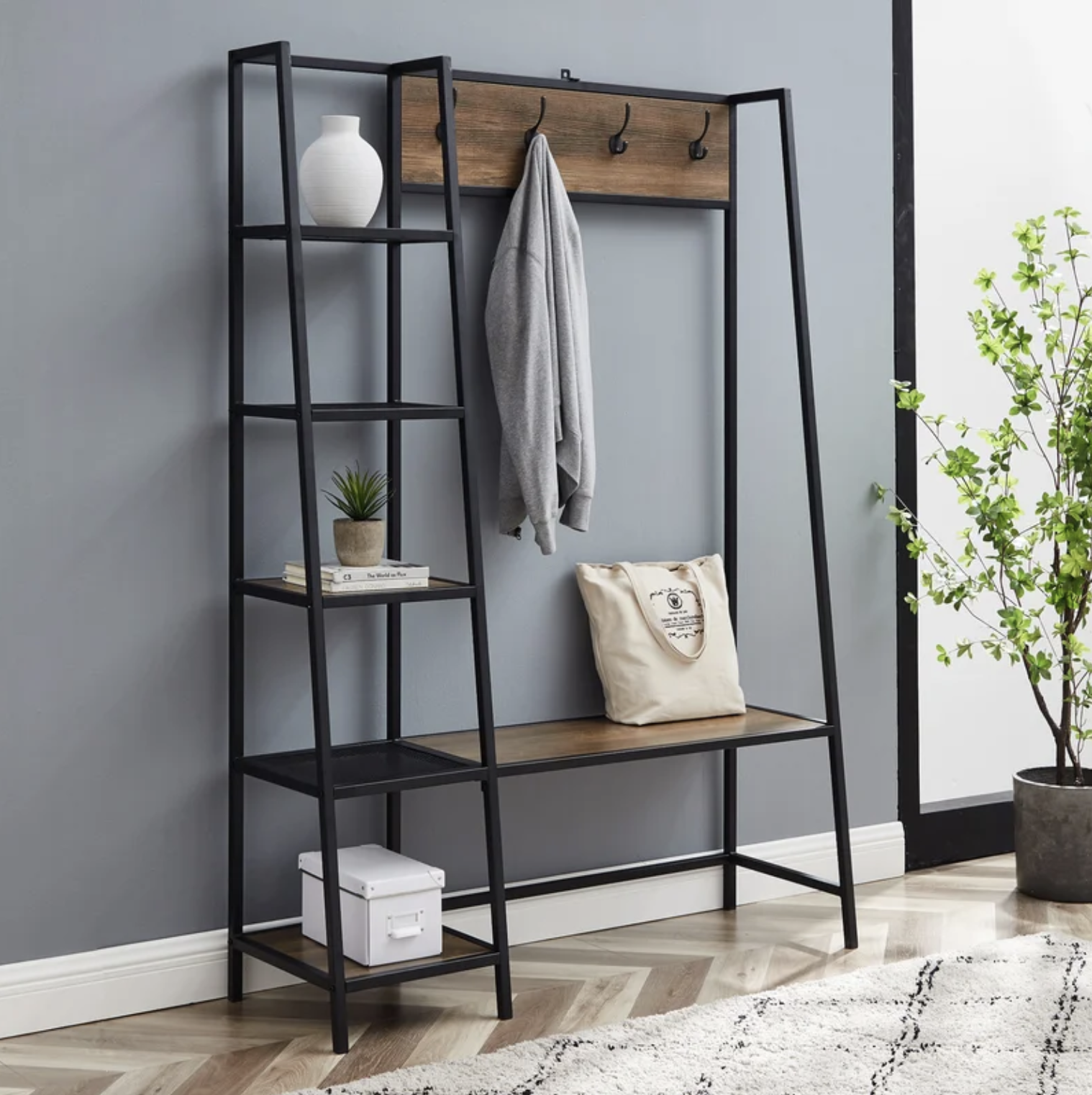 The entryway unit in a hall with a sweater hanging from one of the hooks